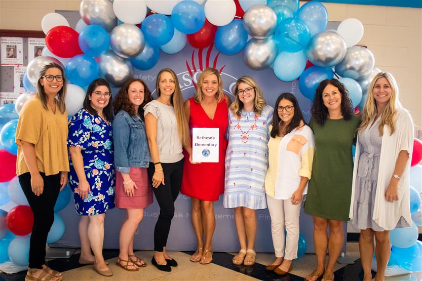 A group of teachers smile